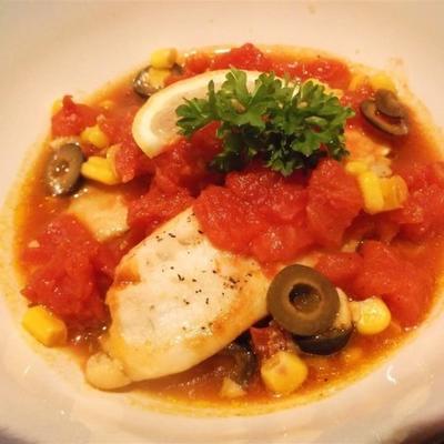 tilapia met tomaten, zwarte olijven en maïs