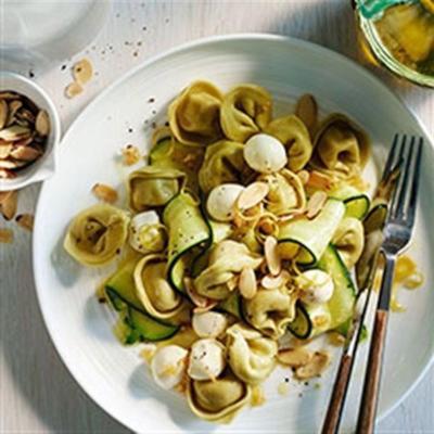 spinazie-kaas tortellini met courgette, mozzarella en geroosterde amandelen