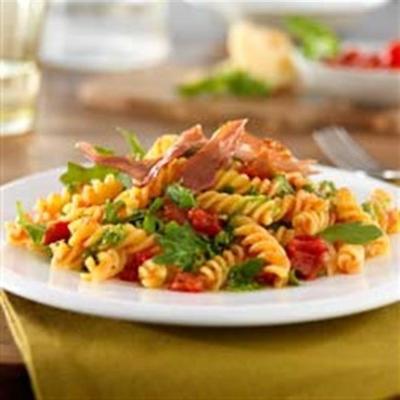 glutenvrije rotini met knapperige prosciutto, pesto en rucola