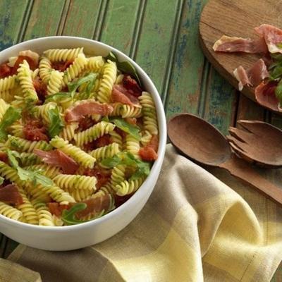 barilla® glutenvrije rotini met basilicumpesto, rucola, geroosterde tomaten en knapperige prosciutto