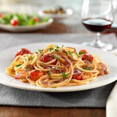 barilla® glutenvrije spaghetti met gekarameliseerde rode uien en hele cherrytomaatjes, pijnboompitten en pecorinokaas