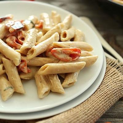 romige veganistische knoflookpasta met geroosterde tomaten