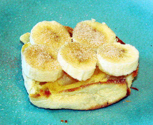 Engelse muffins gegarneerd met bananen en kaneelsuiker.