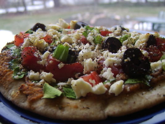 pita pizza's met hummus, spinazie, olijven, tomaten en kaas