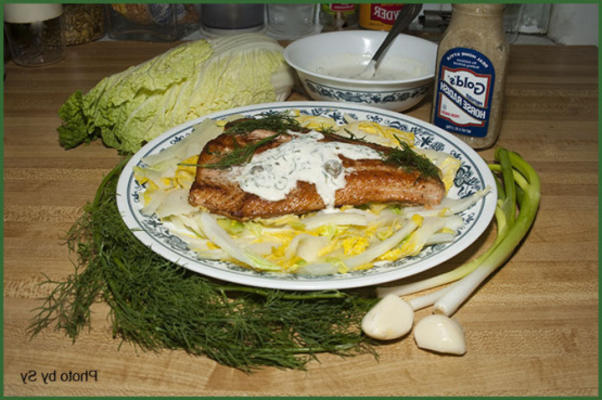 zalm met een romige saus op een bedje van greens