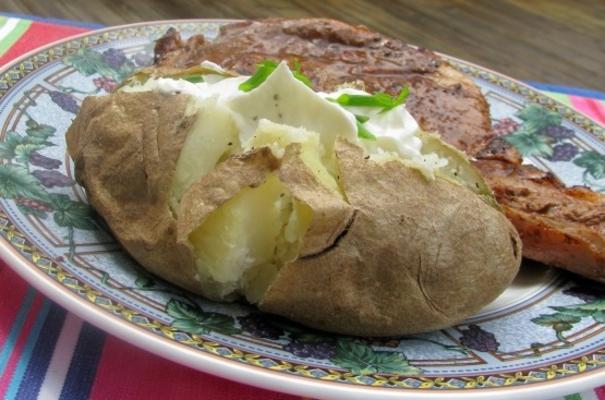 gebakken aardappelen in hun jassen met zure room bijvullen