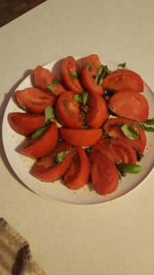 gesneden tomatensalade met kappertjes en basilicum
