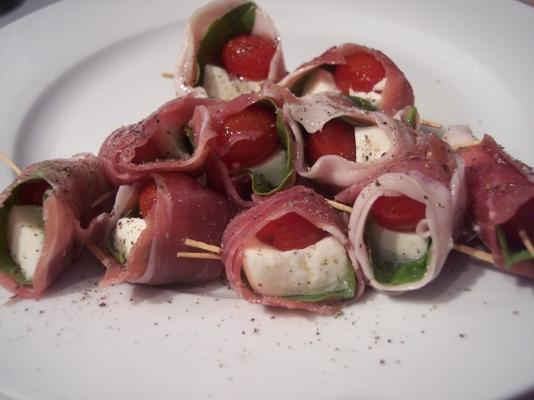 met prosciutto omwikkelde mozzarella en basilicum